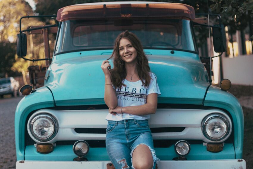 photo of woman leaning on vehicle
